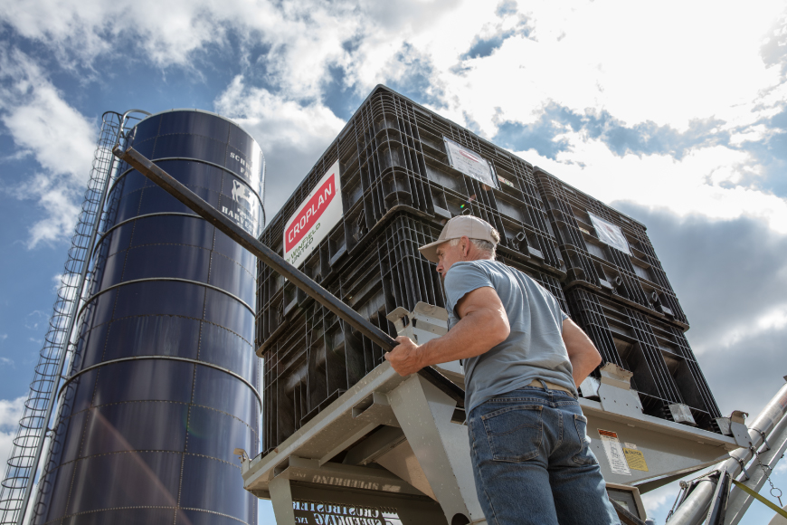 Man standing in front of totes of CROPLAN® seed