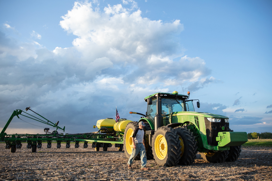 Farmer walking in front of a tractor and planter