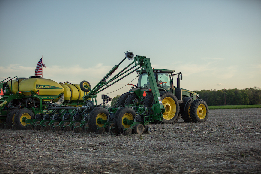 Tractor pulling a planter in a farm field