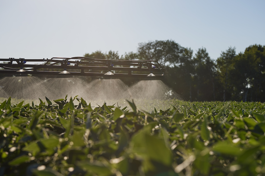 Spraying fungicide onto a late-season field