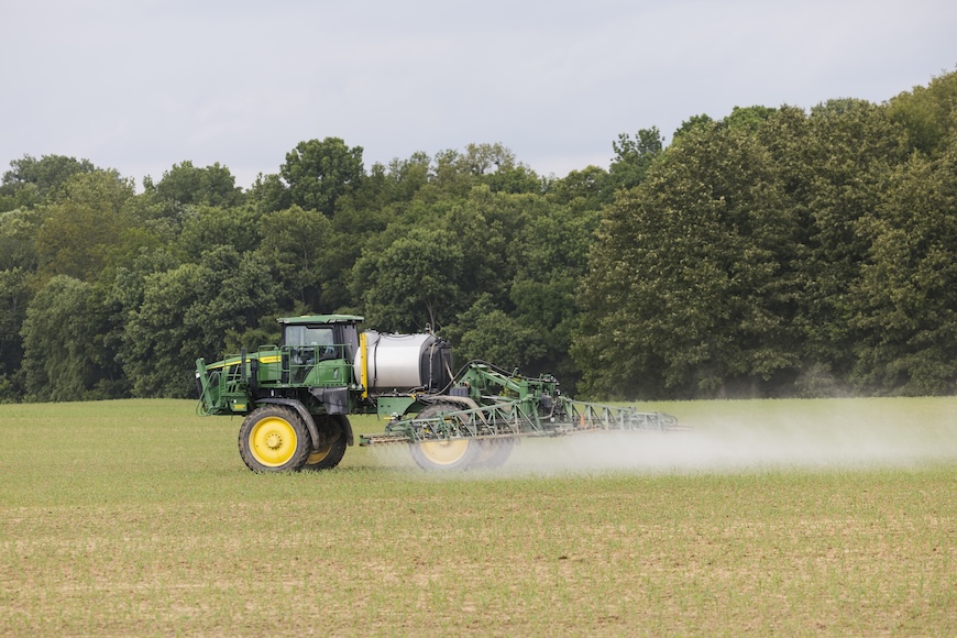 Sprayer driving through early-season field