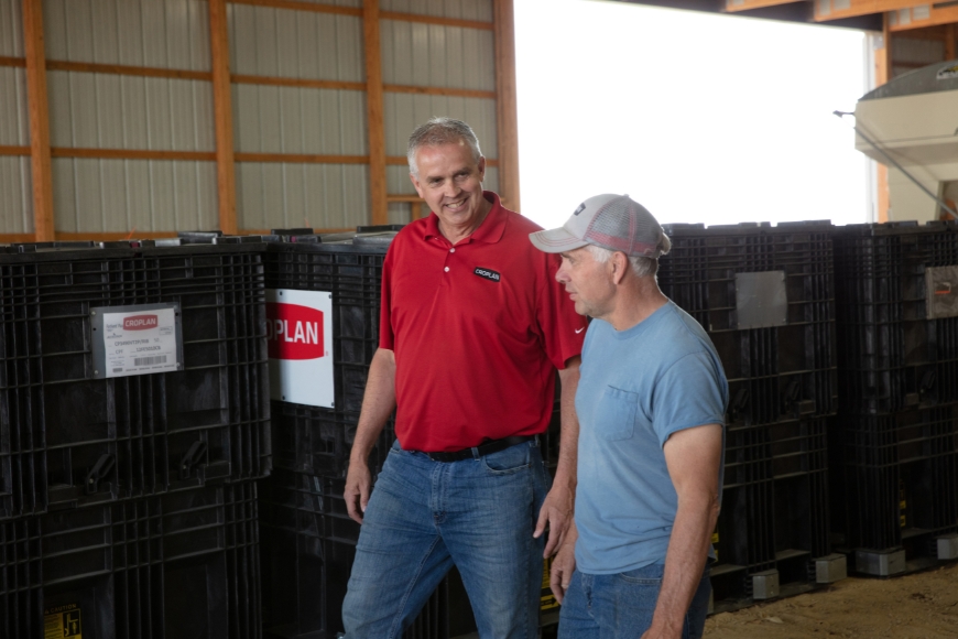 CROPLAN retailer and farmer walking in a farm shed.