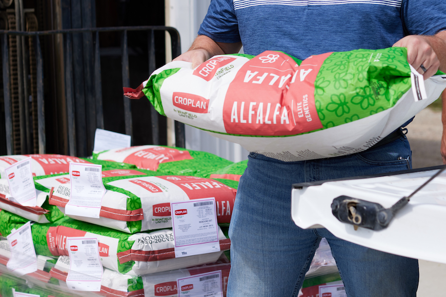 Retailer loading CROPLAN alfalfa seed into a pickup truck.