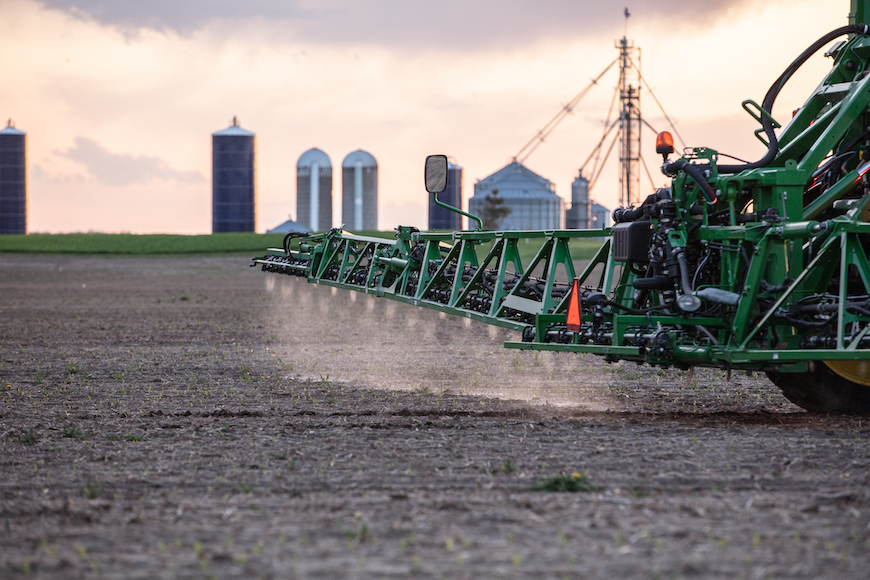 Close up of a sprayer applying herbicide to an early-spring field